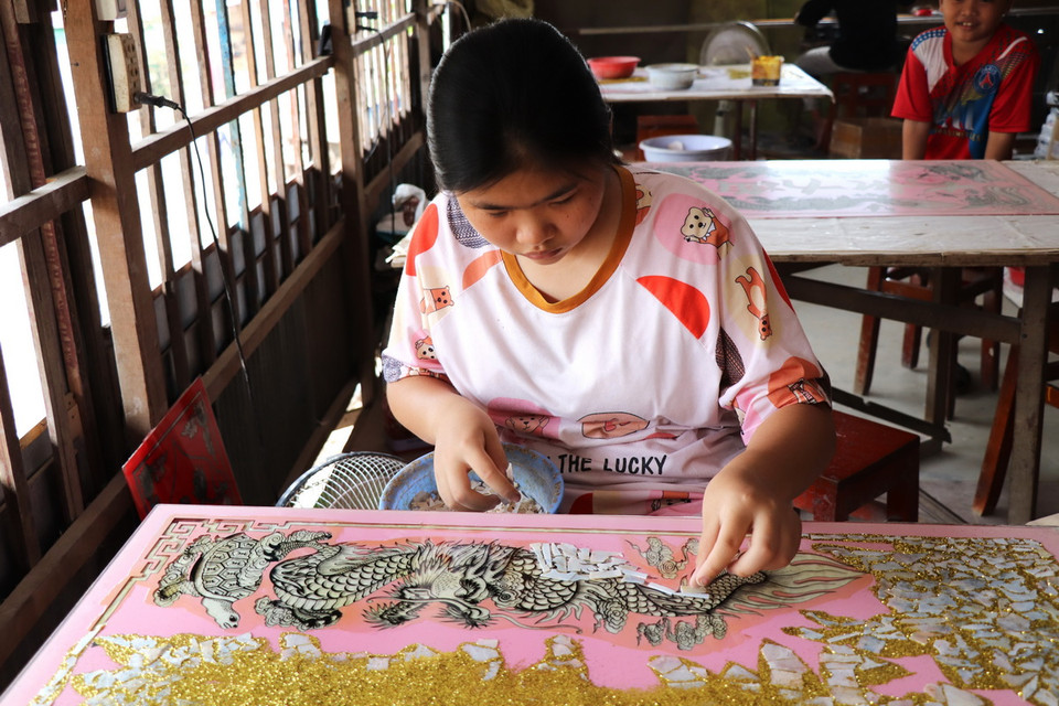 Công đoạn cẩn xà cừ trên tranh kính. (Ảnh: Thanh Sang/TTXVN)