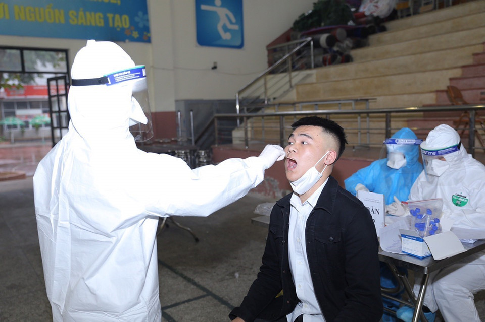 Lấy mẫu xét nghiệm cho người dân về từ vùng dịch tại Trường THPT Phan Huy Chú (quận Đống Đa) chiều 31/1. (Ảnh: Hoàng Hiếu/TTXVN)