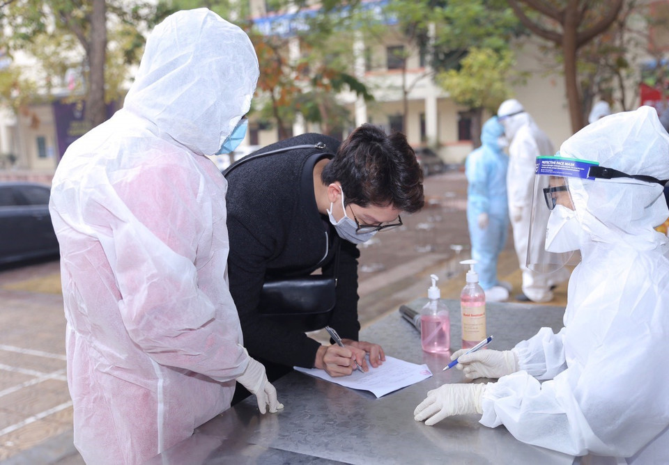 Hướng dẫn người dân về từ vùng dịch khai báo y tế (tại Trường THPT Phan Huy Chú, quận Đống Đa chiều 31/1). (Ảnh: Hoàng Hiếu/TTXVN)