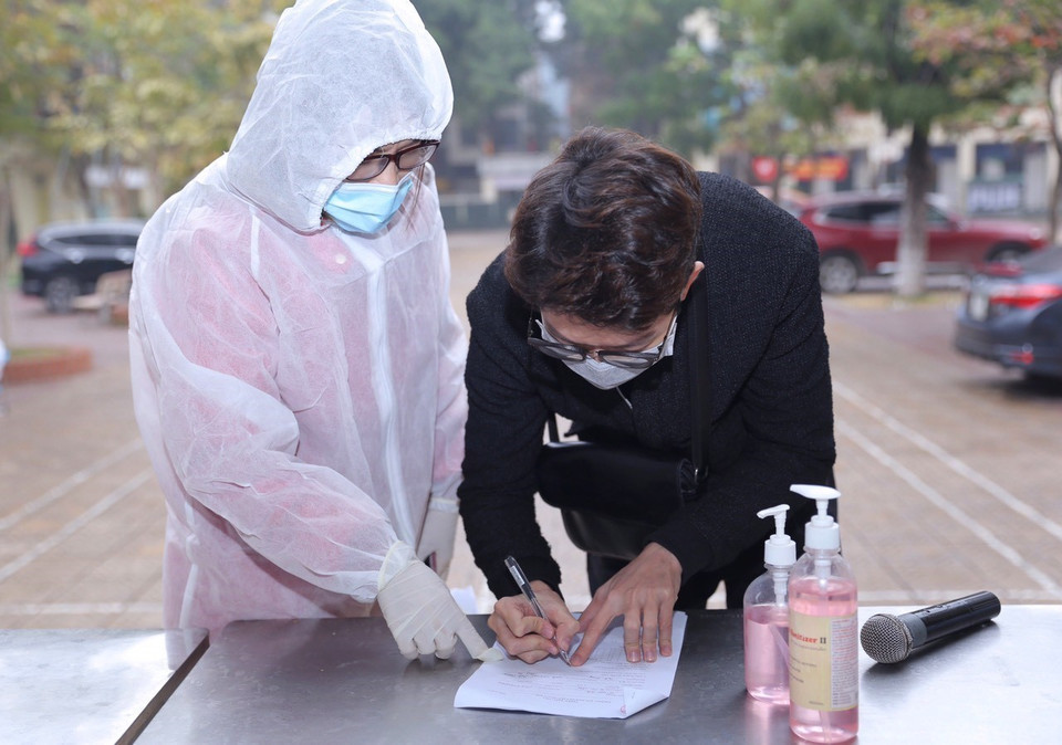 Hướng dẫn người dân về từ vùng dịch khai báo y tế (tại Trường THPT Phan Huy Chú, quận Đống Đa chiều 31/1). (Ảnh: Hoàng Hiếu/TTXVN)