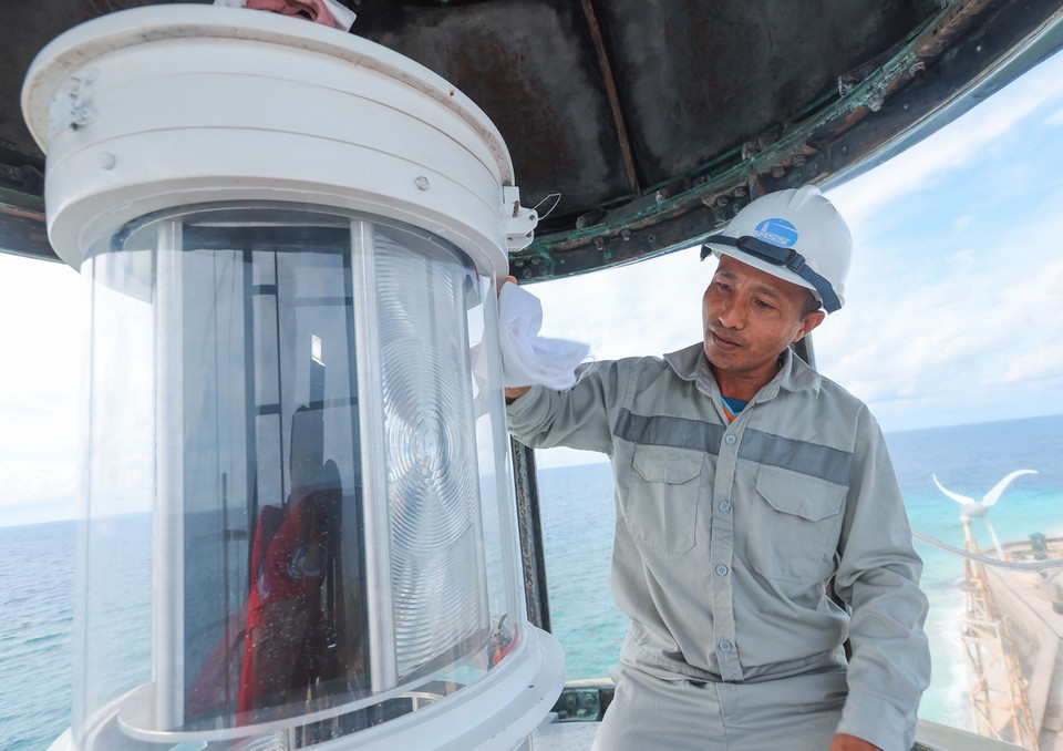 Công nhân Công ty đảm bảo an toàn hàng hải Biển Đông và Hải đảo (Tổng Công ty bảo đảm an toàn hàng hải miền Nam) Nguyễn Minh Thắng bảo dưỡng đèn hải đăng trên đảo An Bang. (Ảnh: Hoàng Hiếu/TTXVN)
