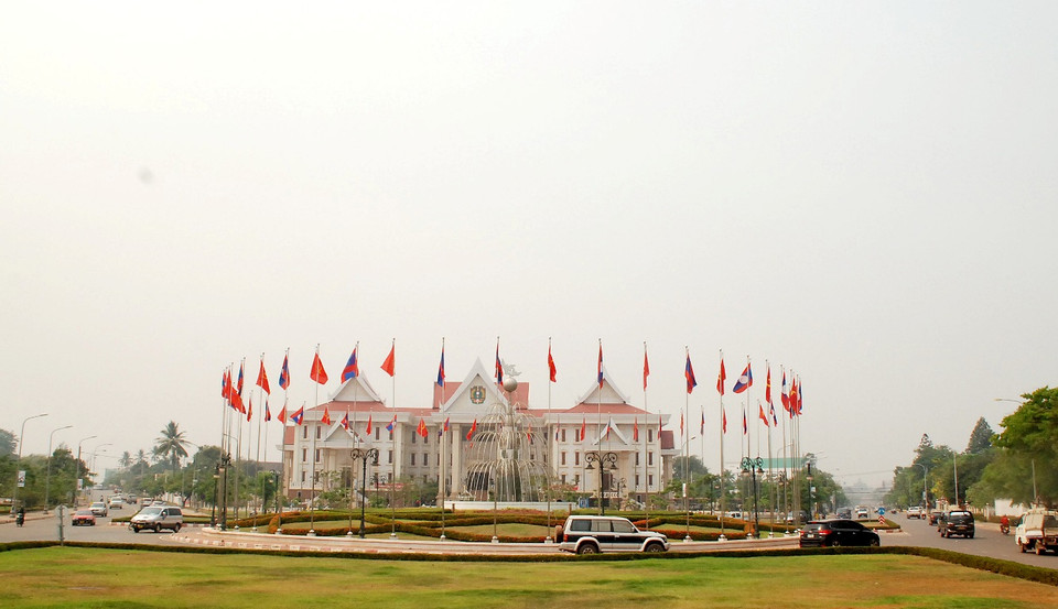 Cờ được trang hoàng tại vòng xuyến trước cửa Bảo tàng Công an Nhân dân Lào. (Ảnh: Phạm Kiên/Vietnam+)