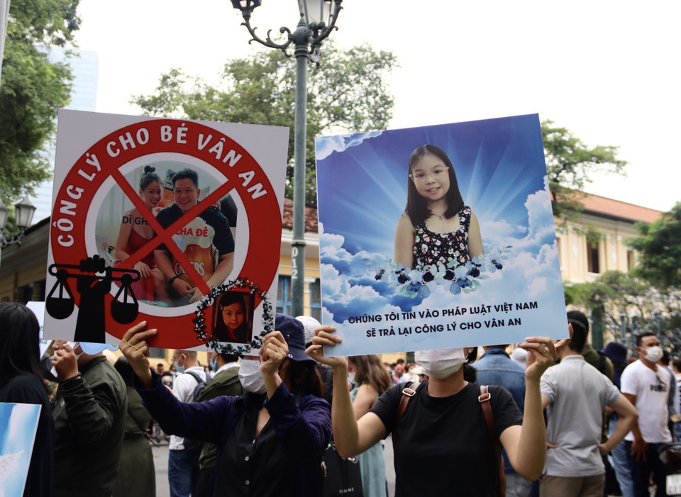 Rất đông người dân trong và ngoài Thành phố Hồ Chí Minh căng biểu ngữ ủng hộ người bị hại và theo dõi vụ án bên ngoài phiên tòa. (Ảnh: Thanh Vũ/TTXVN)