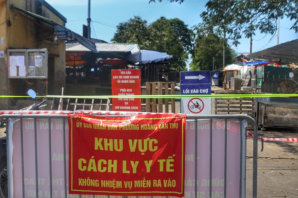 Lực lượng chức năng tiến hành làm rào chắn, phong tỏa tạm thời chợ đầu mối phía Nam. (Ảnh: Tuấn Đức/TTXVN)