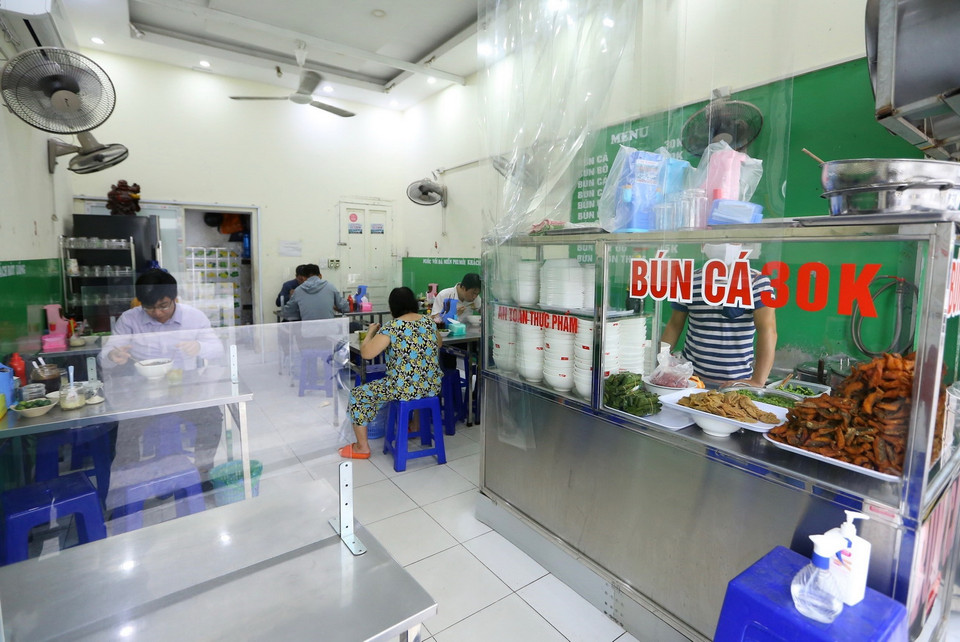 Quán bún cá trên phố Mai Hắc Đế lắp tấm chắn đảm bảo an toàn phòng, chống COVID-19. (Ảnh: Hoàng Hiếu/TTXVN)