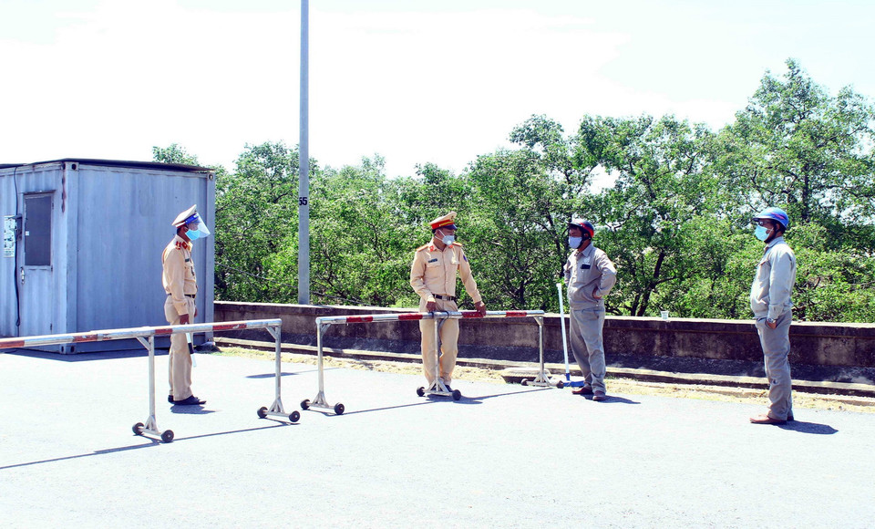  Cán bộ chiến sỹ Cảnh sát giao thông thành phố Vinh "căng mình" dưới nắng nóng để giải thích cho người dân không được qua chốt kiểm soát tại đê xã Hưng Hòa, thành phố Vinh, tỉnh Nghệ An khi không đầy đủ các giấy tờ theo quy định. (Ảnh: Tá Chuyên/TTXVN)