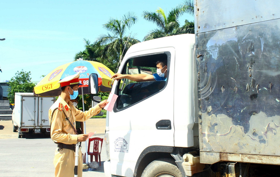  Cán bộ Cảnh sát giao thông thành phố Vinh kiểm tra giấy tờ của các chủ phương tiện khi qua chốt kiểm soát tại cầu Bến Thủy. (Ảnh: Tá Chuyên/TTXVN)
