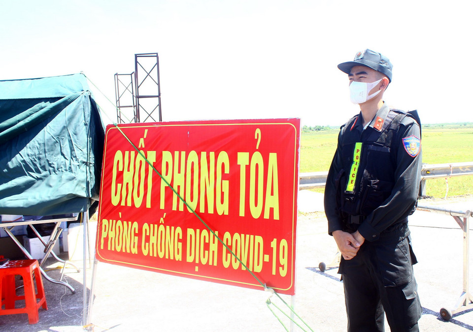 Thiếu úy Trần Hải Hoàn, Phòng cảnh sát cơ động Công an tỉnh Nghệ An, bất chấp nắng nóng để bám chốt tại đê xã Hưng Hòa, kiểm soát chặt người và phương tiện. (Ảnh: Tá Chuyên/TTXVN)