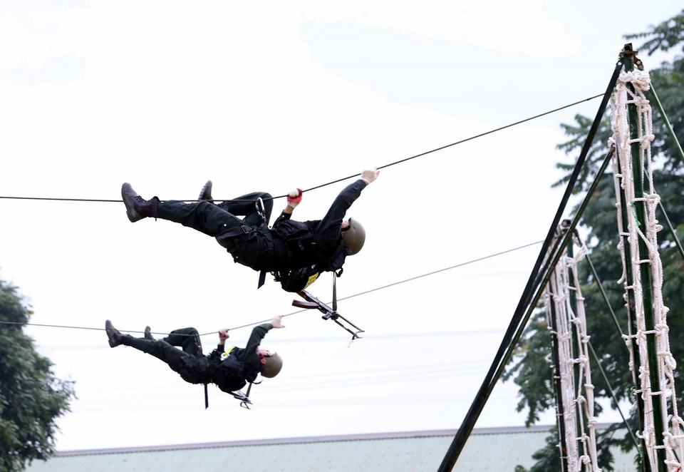 Trong ảnh: Lực lượng CSCĐ diễn tập phương án đu dây tiếp cận khu vực có bọn khủng bố để giải cứu con tin tại buổi diễn tập phương án bảo vệ cuộc Bầu cử đại biểu Quốc hội và đại biểu HĐND các cấp. (Ảnh: Phạm Kiên/TTXVN)