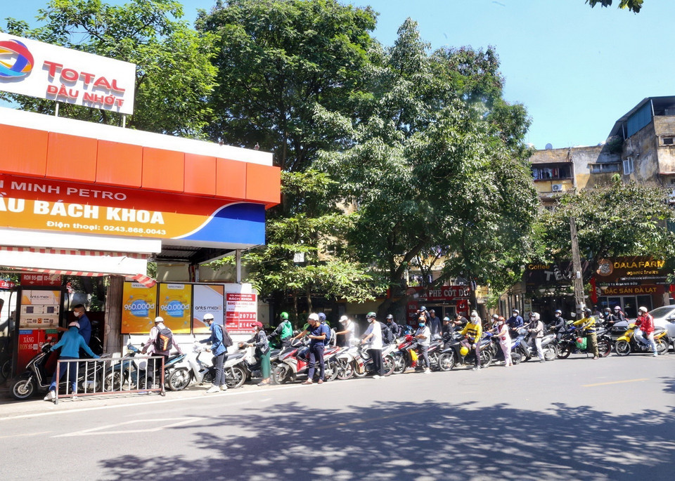 Người dân mua xăng xếp hàng dài tại cửa hàng xăng Bách Khoa. (Ảnh: Tuấn Đức/TTXVN)