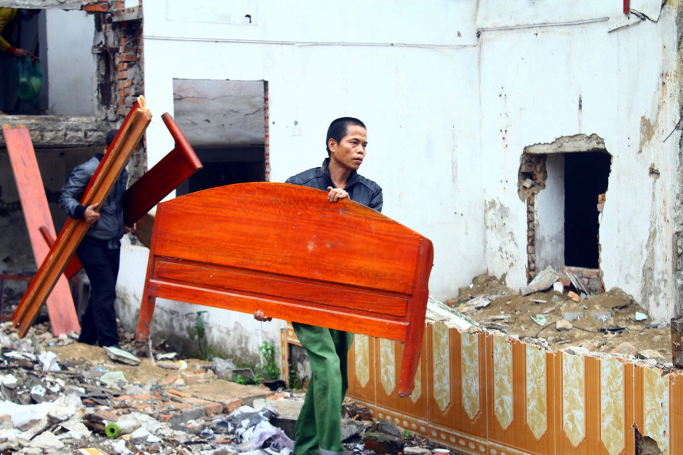 Người dân tiến hành vận chuyển đồ đạc ra khỏi chung cư Quang Trung. (Ảnh: Tá Chuyên/TTXVN)