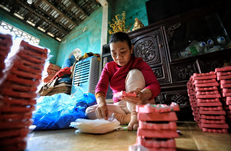 Tượng ông Công, ông Táo sẽ có 2 màu chính là đỏ sẫm do nhuộm sơn mài hoặc màu hồng, sau khi nung tượng được phủ một lớp sơn, trang trí và gắn kim tuyến. (Ảnh: Thành Đạt/TTXVN)