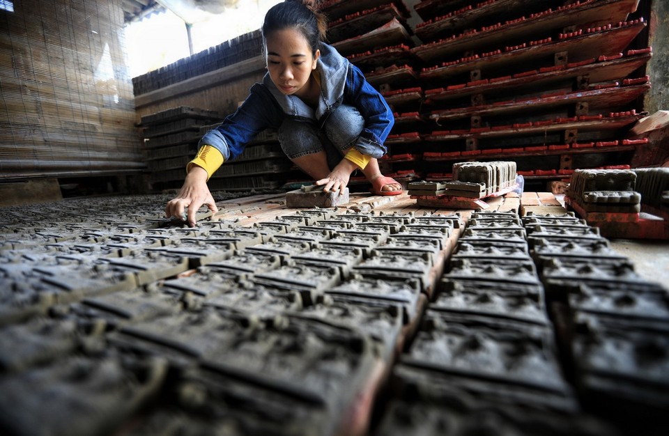 Để tượng không bị vỡ nát, hư hỏng, khi đưa tượng vào lò, người thợ cần phải sắp xếp thành từng hàng, nhiều lớp trên dưới xen kẽ, giữa các lối cần có khoảng cách để lửa cháy đều. (Ảnh: Thành Đạt/TTXVN)