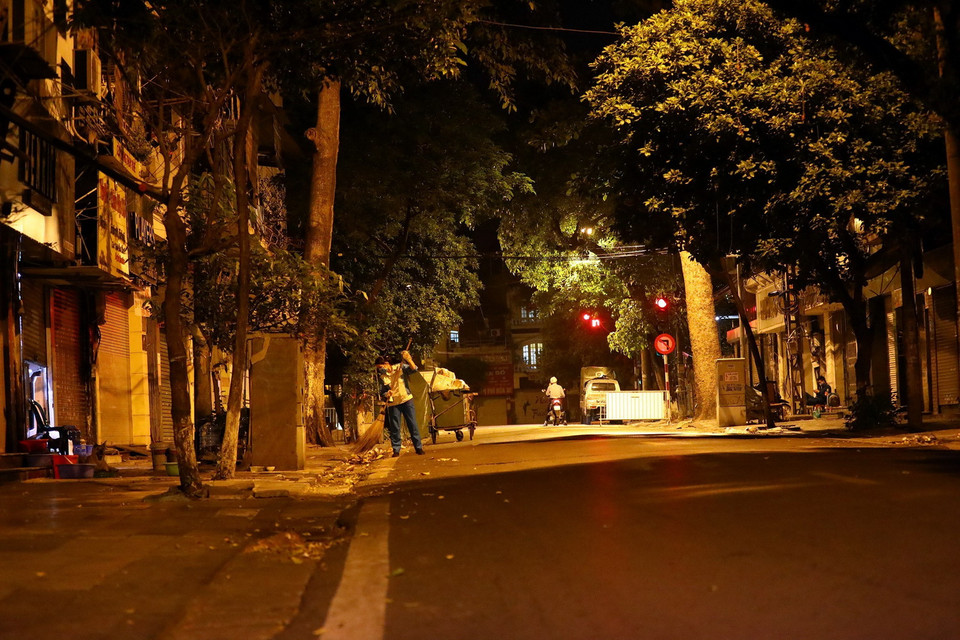 Tối đến, đêm về, trên các con phố chỉ còn thấy hình bóng quen thuộc của các chị lao công quét rác. (Ảnh: Huy Hùng/TTXVN)