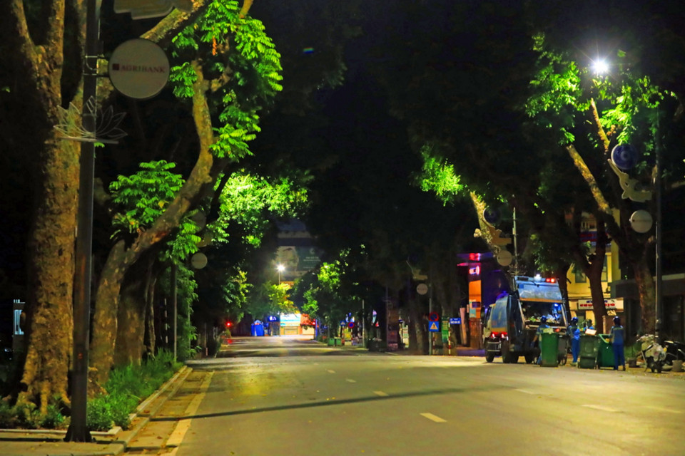 Đêm về, chỉ còn những người làm công tác dọn vệ sinh trên phố Bà Triệu xanh mướt hai hàng cây. (Ảnh: Tuấn Anh/TTXVN)