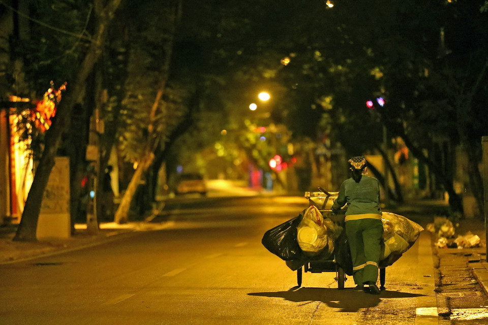 Các cô lao công vẫn đêm đêm cần mẫn thực hiện công việc làm đẹp cho những ngõ phố Thủ đô. (Ảnh: Huy Hùng/TTXVN)