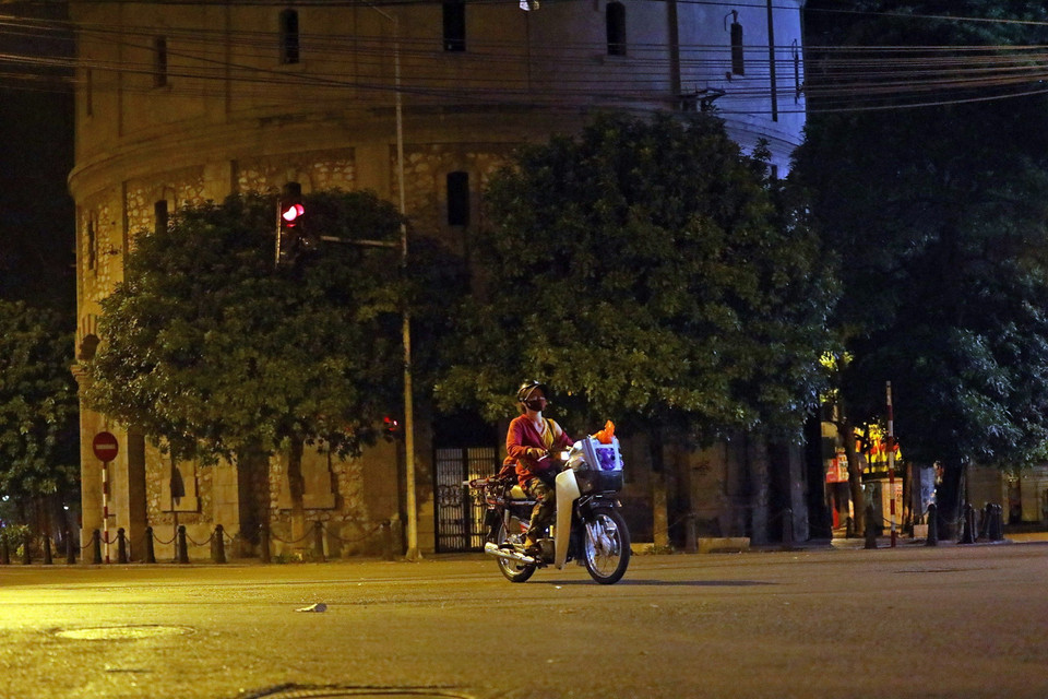 Người dân đi làm ca đêm vội trở về nhà qua khu vực bốt Hàng Đậu. (Ảnh: Huy Hùng/TTXVN)