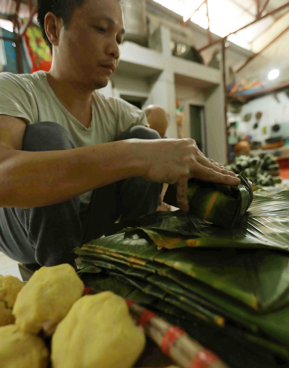 Người làng Tranh Khúc gói bánh bằng tay chứ không cần dùng khuôn, nhưng bánh rất vuông vức và đẹp mắt. (Ảnh: Vũ Sinh/TTXVN)