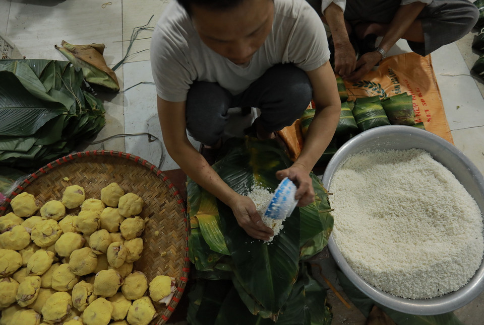 Người Tranh Khúc chỉ gói bánh chưng bằng tay mà không cần dùng đến khuôn và mỗi chiếc bánh chỉ mất chưa đầy 1 phút là hoàn thành. (Ảnh: Vũ Sinh/TTXVN)