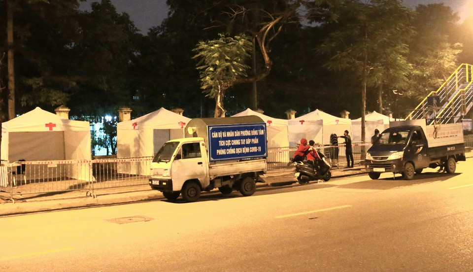 Lực lượng Công an phường Đồng Tâm triển khai phương án bảo vệ Trạm di động lấy mẫu xét nghiệm COVID-19. (Ảnh: Doãn Tấn/TTXVN)