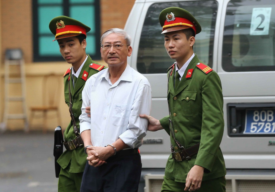 Cảnh sát dẫn giải bị cáo Nguyễn Xuân Thắng (sinh năm 1955), nguyên là thành viên Hội đồng thành viên PVN vào phòng xét xử. (Ảnh: Doãn Tấn/TTXVN)