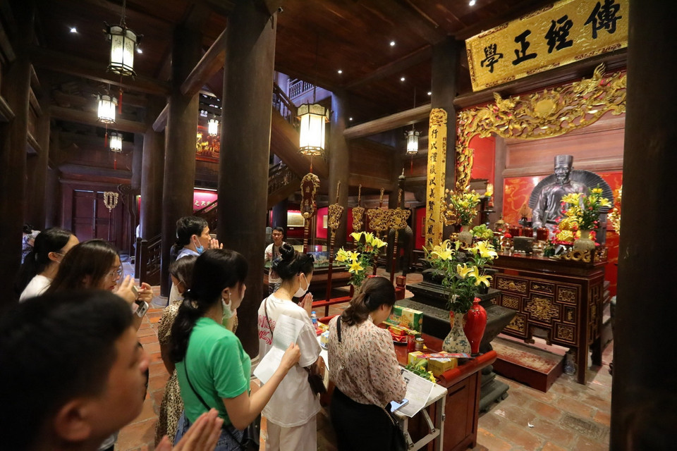 Phụ huynh và sỹ tử đến Khu Di tích Quốc gia Đặc biệt Văn Miếu-Quốc Tử Giám cầu mong may mắn trong kỳ thi sắp tới. (Ảnh: Hoàng Hiếu/TTXVN)