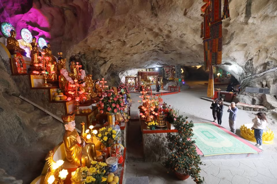 Du khách lễ Tam Bảo - nơi thờ Phật trong chùa Tam Thanh giữa không gian tâm linh huyền ảo của động núi đá. (Ảnh: Anh Tuấn/TTXVN)