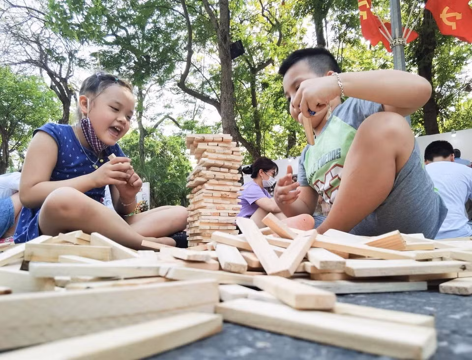 Các em nhỏ háo hức với trò chơi cùng gỗ. (Ảnh: Thanh Tùng/TTXVN)