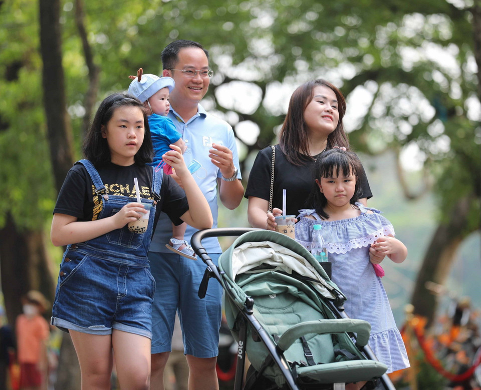 Một gia đình hòa mình cùng không khí sôi động trên phố đi bộ. (Ảnh: Thanh Tùng/TTXVN)