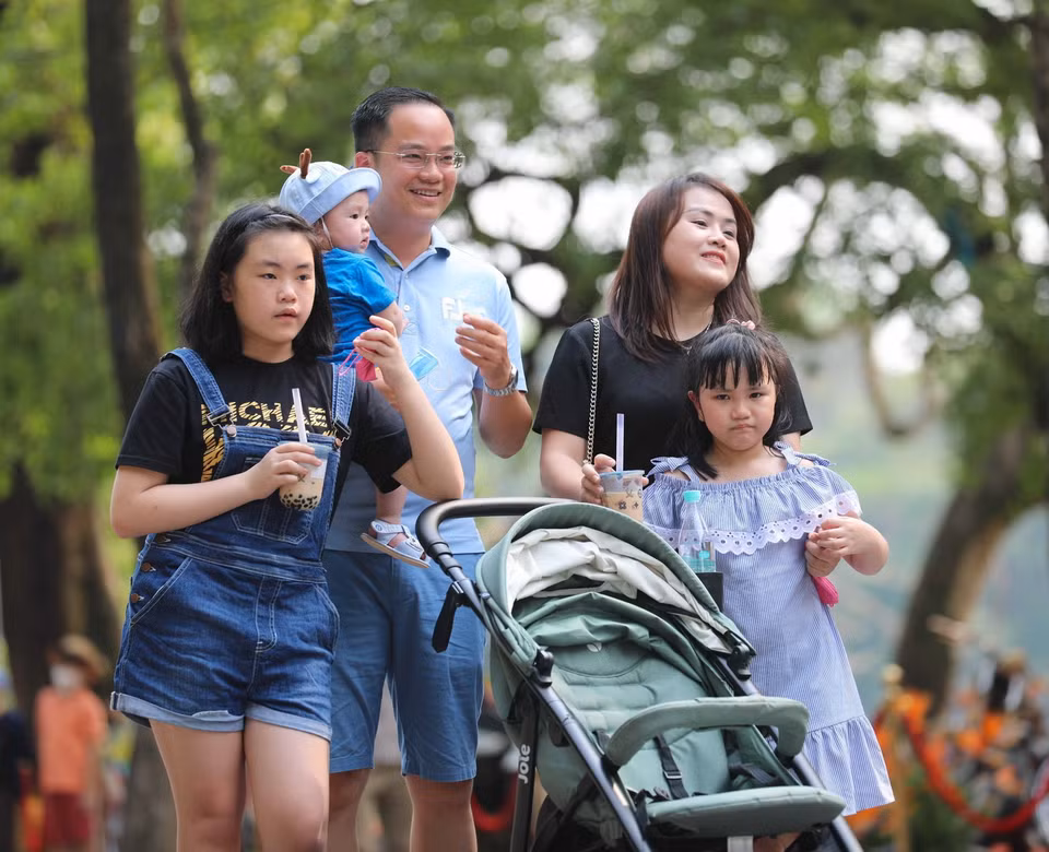 Một gia đình hòa mình cùng không khí sôi động trên phố đi bộ. (Ảnh: Thanh Tùng/TTXVN)