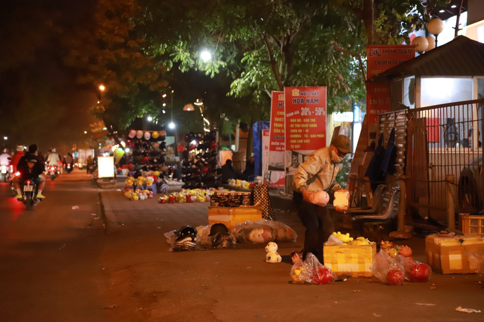 Nhiều sạp hàng rong nhỏ bày bán hàng dưới lòng đường trên phố Tam Trinh (quận Hoàng Mai) (ảnh chụp tối 13/3). (Ảnh: Thanh Thảo/TTXVN phát)