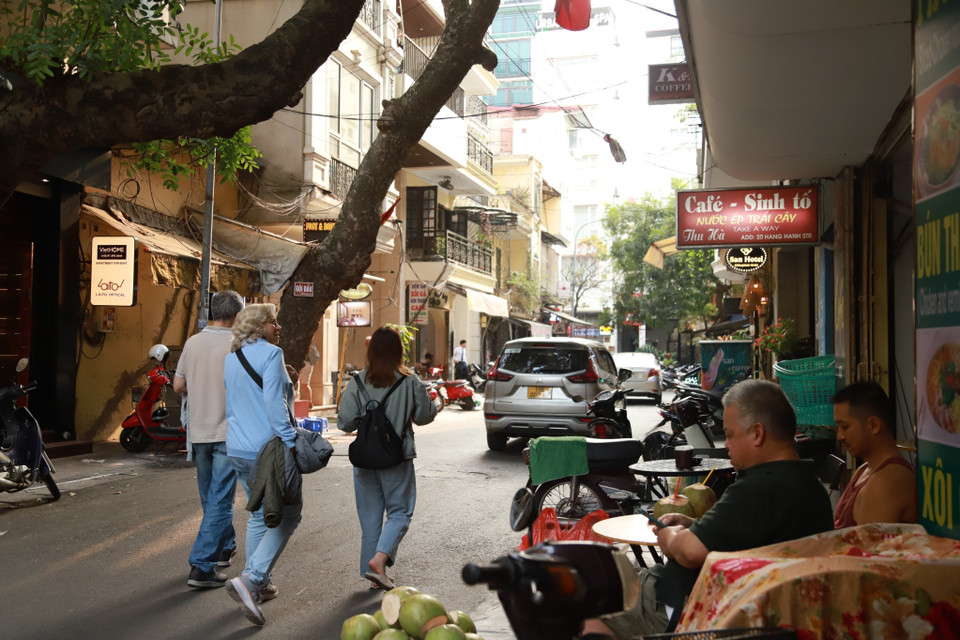 Tại phố Hàng Hành (quận Hoàn Kiếm), rất nhiều ôtô dừng đỗ giữa đường và nhiều hàng quán lấn chiếm vỉa hè khiến du khách phải đi bộ dưới lòng đường. (Ảnh: Thanh Thảo/TTXVN phát)