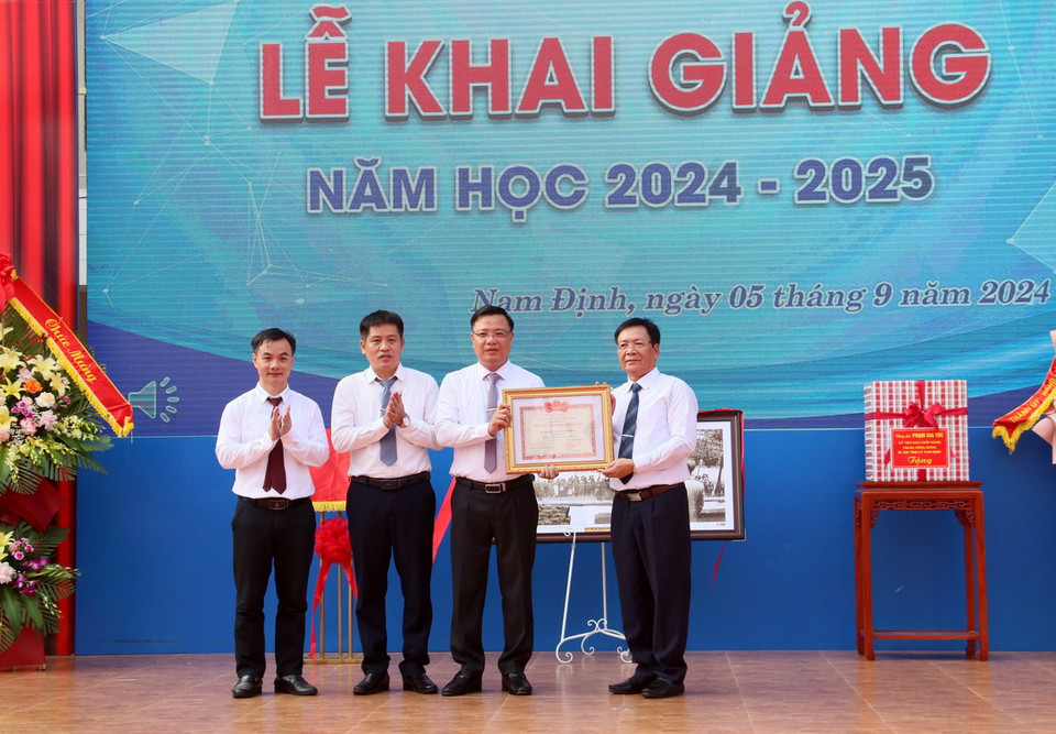 Lãnh đạo Sở Giáo dục và Đào tạo tỉnh Nam Định trao danh hiệu Tập thể lao động xuất sắc cho Trường THPT Chuyên Lê Hồng Phong, thành phố Nam Định nhân lễ khai giảng. (Ảnh: Nguyễn Lành/TTXVN)