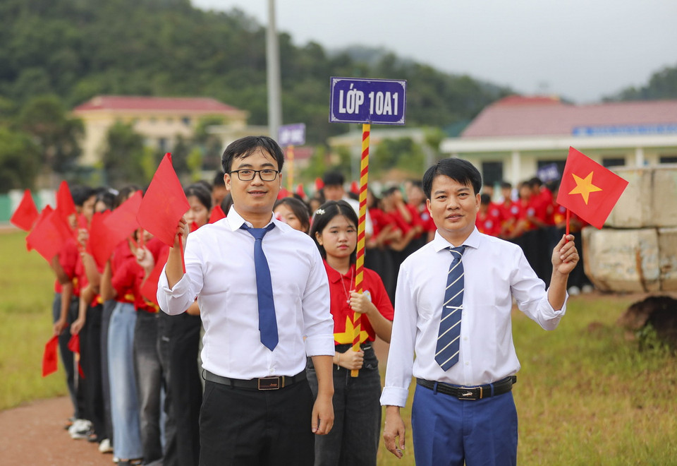 Giáo viên Trường Phổ thông Dân tộc nội trú THPT huyện Nậm Pồ (tỉnh Điện Biên) dẫn học sinh mới khối lớp 10 vào lễ khai giảng. (Ảnh: Xuân Tư/TTXVN)