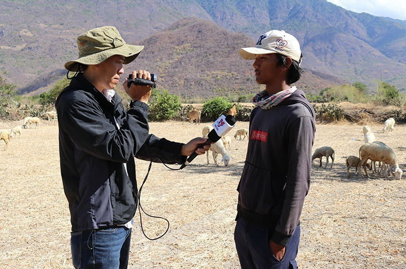Phóng viên Nguyễn Thành phỏng vấn người chăn nuôi gia súc tại xã Phước Trung, huyện Bác Ái, tỉnh Ninh Thuận giữa mùa hạn hán 2020. (Ảnh: TTXVN)