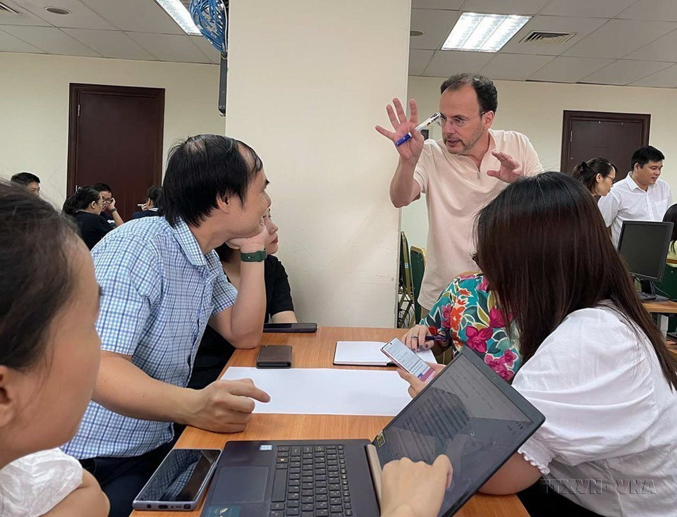 Nhà báo Alain Gérard trao đổi với các học viên về phương thức tổ chức một bài báo hiện đại trên trang thông tin điện tử với các phóng viên, biên tập viên của Thông tấn xã Việt Nam. (Ảnh: TTXVN)