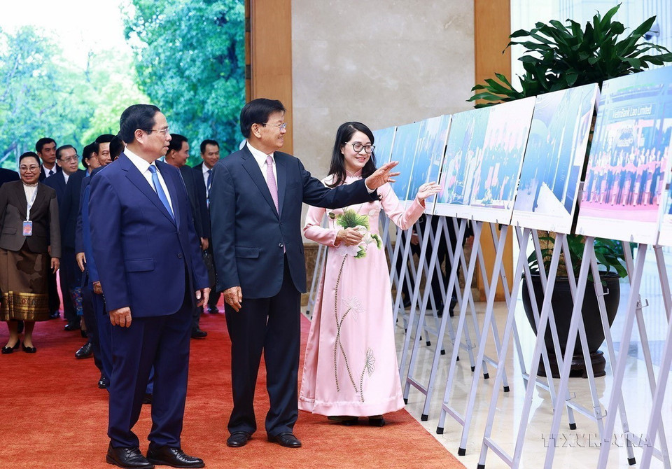 Thủ tướng Phạm Minh Chính và Tổng Bí thư, Chủ tịch nước Lào Thongloun Sisoulith xem trưng bày những hình ảnh tiêu biểu về quan hệ Việt-Lào, do TTXVN thực hiện (10/9/2024). (Ảnh: Dương Giang/TTXVN)