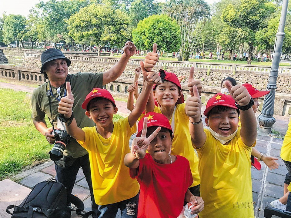 Phóng viên Báo ảnh Việt Nam Đặng Thanh Hòa tác nghiệp tại Cố đô Huế, tháng 5/2023. (Ảnh: TTXVN)