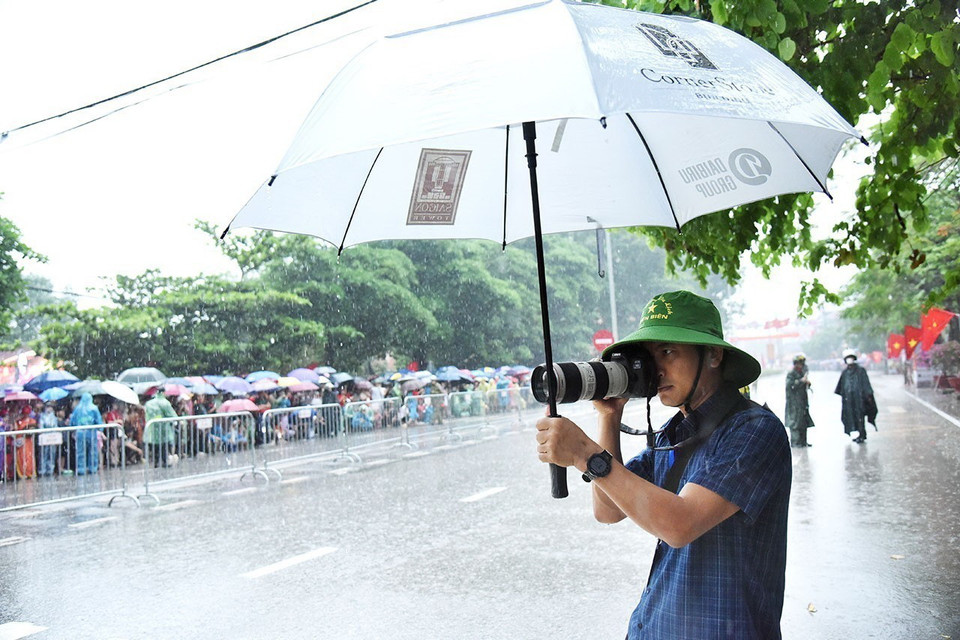 Trưởng CQTT TTXVN tại Điện Biên Nguyễn Trung Kiên tác nghiệp trên đường phố tại Lễ kỷ niệm 70 năm Chiến thắng Điện Biên Phủ, ngày 7/5/2024. (Ảnh: TTXVN)