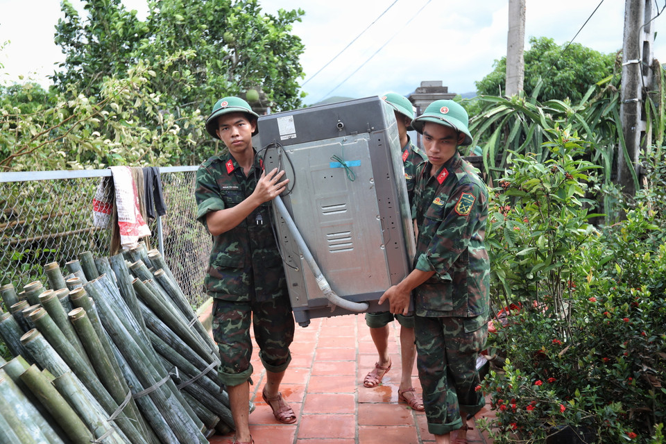 Cán bộ, chiến sỹ Sư đoàn 325 giúp dân vận chuyển đồ đạc tại thôn Khả Lã, xã Tân Lập, Lục Ngạn. (Ảnh: Danh Lam/TTXVN)