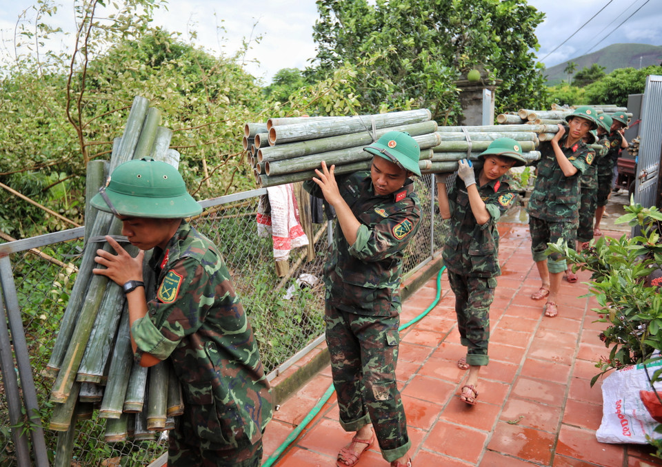 Cán bộ, chiến sỹ Sư đoàn 325 giúp dân vận chuyển đồ đạc tại thôn Khả Lã, xã Tân Lập, huyện Lục Ngạn. (Ảnh: Danh Lam/TTXVN)