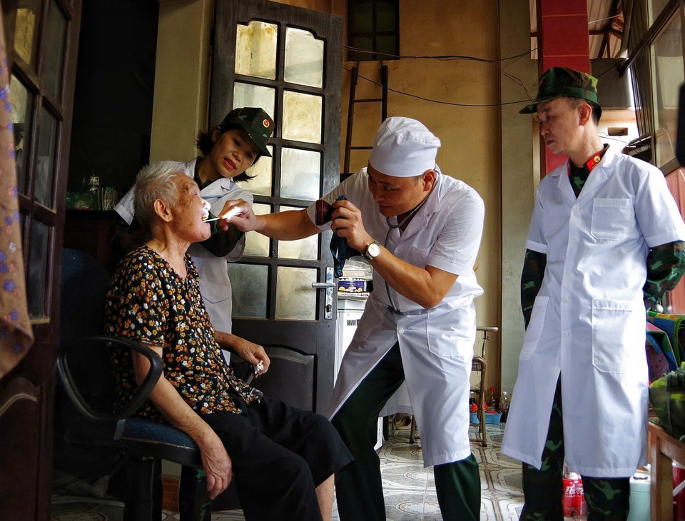 Cán bộ, chiến sỹ Sư đoàn 325 khám, chữa bệnh cho nhân dân trong vùng lũ. (Ảnh: Danh Lam/TTXVN)