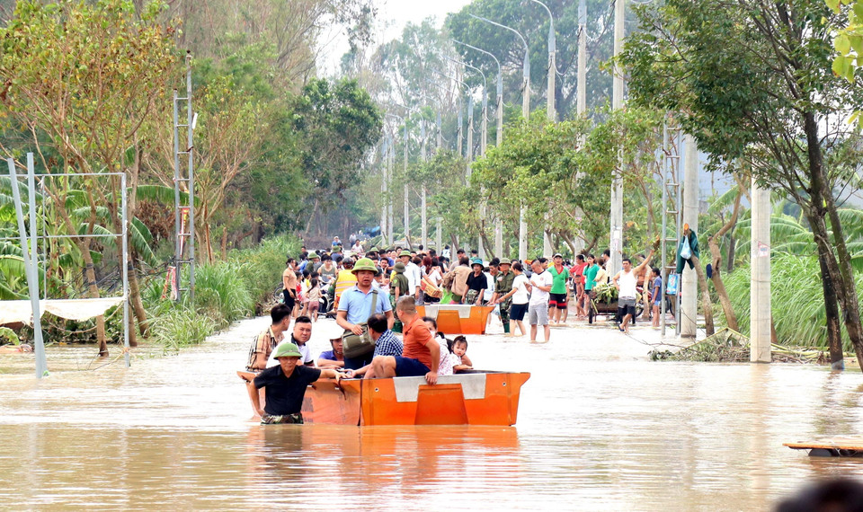 Trong lúc chờ cầu phao được lắp đặt xong, người dân xã Phú Cường, thành phố Hưng Yên, di chuyển bằng xuồng cứu sinh. (Ảnh: Đinh Văn Nhiều/TTXVN)