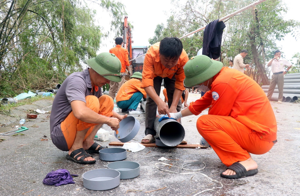 Lực lượng chức năng sử dụng ống nhựa để làm cầu phao phục vụ việc đi lại của nhân dân xã Phú Cường, thành phố Hưng Yên. (Ảnh: Đinh Văn Nhiều/TTXVN)