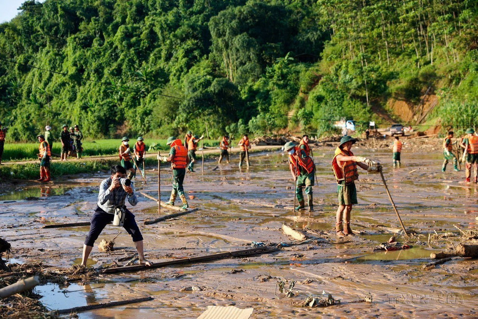 Phóng viên Dương Giang (Ban Biên tập Ảnh) tác nghiệp tại khu vực sạt lở đất ở làng Nủ, xã Phúc Khánh, huyện Bảo Yên, tỉnh Lào Cai (12/9/2024). (Ảnh: TTXVN)