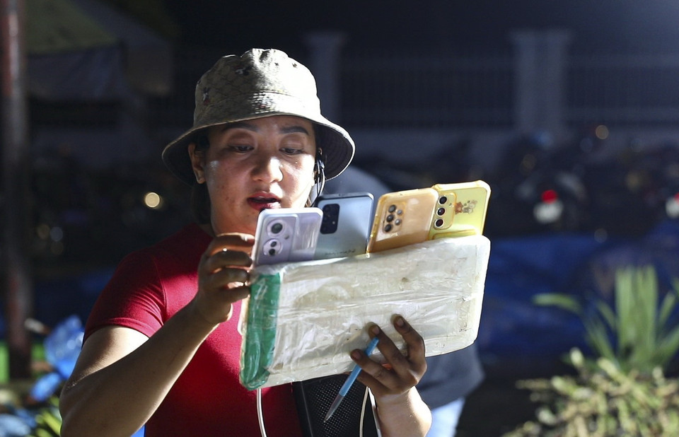 Hoạt động livestream bán hàng tại chợ đêm. (Ảnh: Xuân Tư/TTXVN)