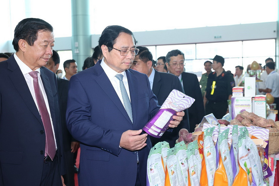 Thủ tướng Phạm Minh Chính tìm hiểu về sản phẩm nông nghiệp của tỉnh Vĩnh Long. (Ảnh: Dương Giang/TTXVN)