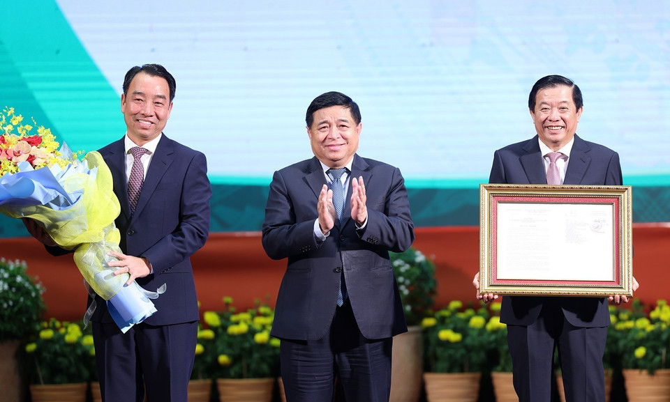 Bộ trưởng Bộ Kế hoạch và Đầu tư Nguyễn Chí Dũng trao công bố Quy hoạch cho lãnh đạo tỉnh Vĩnh Long. (Ảnh: Dương Giang/TTXVN)