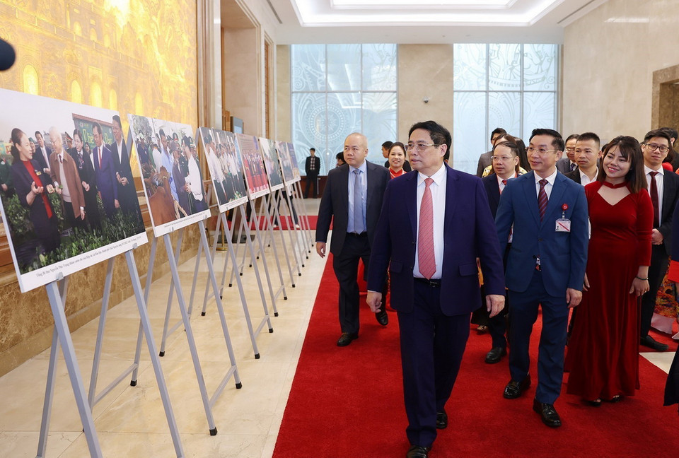 Thủ tướng Phạm Minh Chính và các đại biểu tham quan trưng bày ảnh về kinh tế hợp tác, hợp tác xã, do TTXVN thực hiện. (Ảnh: Dương Giang/TTXVN)