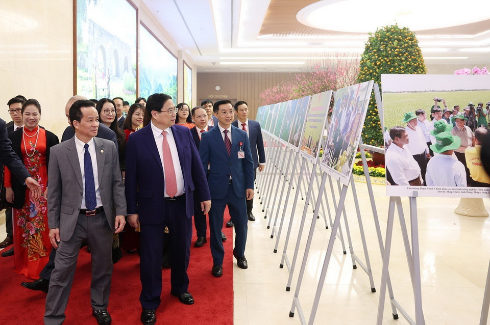 Thủ tướng Phạm Minh Chính và các đại biểu tham quan trưng bày ảnh về kinh tế hợp tác, hợp tác xã, do TTXVN thực hiện. (Ảnh: Dương Giang/TTXVN)